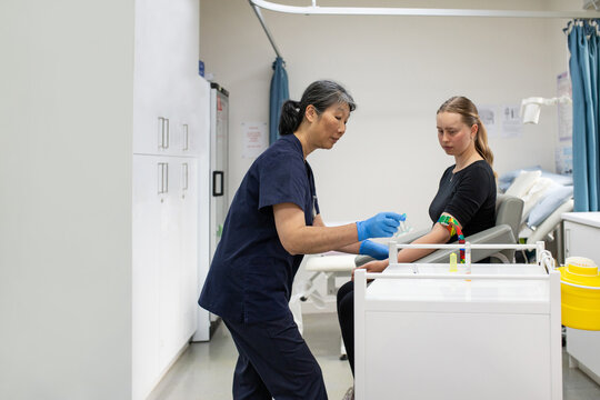 woman in the clinic getting a blood test by a female health worker