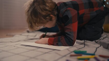 Cute little boy drawing with pencil, creative hobbies for children at home