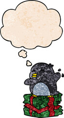 cartoon penguin on present with thought bubble in grunge texture style