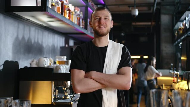 young bartender looking at the camera and smiling. slow motion . High quality 4k footage