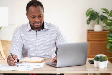 Fototapeta premium African American businessman smiling relaxed and crossed arms after analysis and research at home office