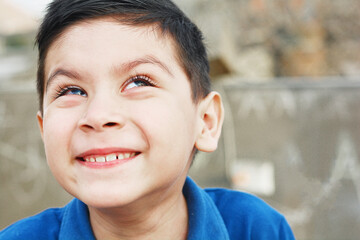 Sly little latin boy looking up.