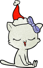 hand drawn textured cartoon of a cat with bow on head wearing santa hat