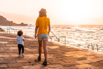 Mother with her son at sunset in the La Maceta rock pool on the island of El Hierro en la Frontera, Canary Islands