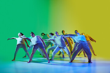 Dance team of young beautiful girls moving to the beat of the music on gradient background in neon...