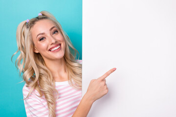 Photo of young cheerful attractive girl direct finger banner recommend cheap price proposition enjoy stomatology isolated on cyan color background