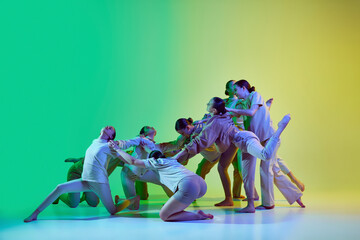 Group of teenagers, young dancers emotionally dancing together on gradient background in neon...