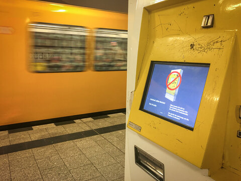 Broken BVG Metro (U-Bahn) Ticket Vending Machine showing out of order on the display. a train is passing by in the background.