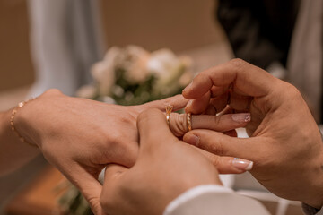 Obraz na płótnie Canvas Noivo colocando a aliança na mão da noiva no dia do casamento