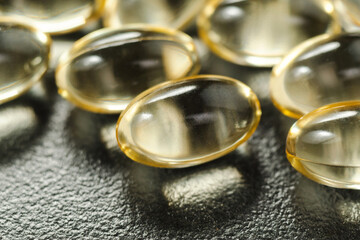 Yellow oil soft gel capsules. Cosmetic pill capsule of vitamin E, A, almond oil, Omega 3, fish.