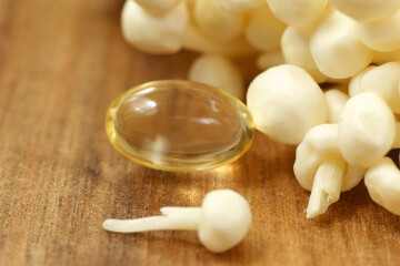 Fototapeta na wymiar Mushroom or enoki close up medical use, dietary supplements, pills capsules. Golden needle mushroom.