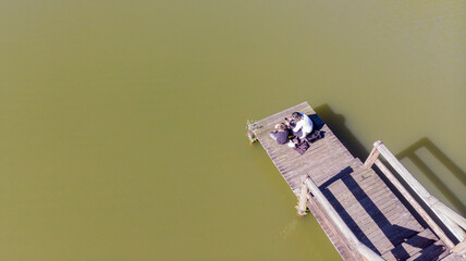 Overhead shot of mother and son sitting on lakeside deck
