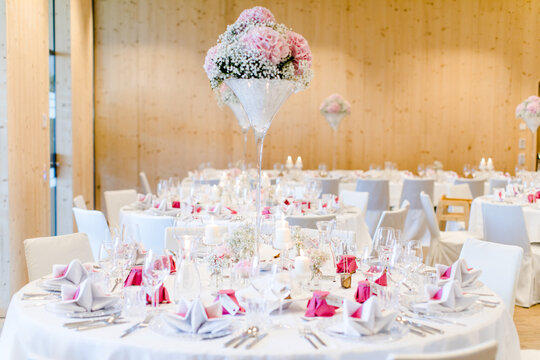 Feierlich gedeckter Festsaal in rosa weiß bei Hochzeitsfeier im Restaurant