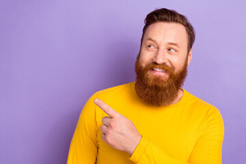Portrait picture of young smiling guy wear yellow pullover direct finger looking empty space good...
