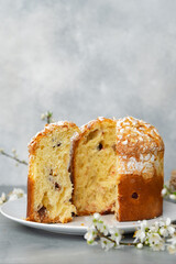 Cut Easter cake on plate decorated with spring flower branches