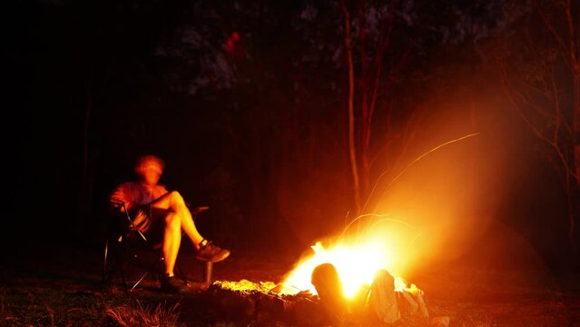 timelapse of man sitting by a campfire, camping in the australian bush 