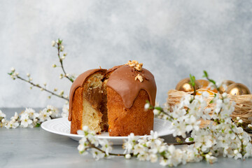 Cut Easter cake on plate decorated with spring flower branches