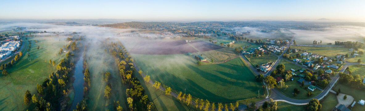 Panoramic view of mist over river and small hobby farmland in country town