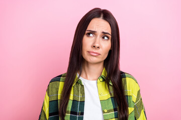 Fototapeta premium Photo of unhappy upset woman dressed plaid shirt looking empty space isolated pink color background
