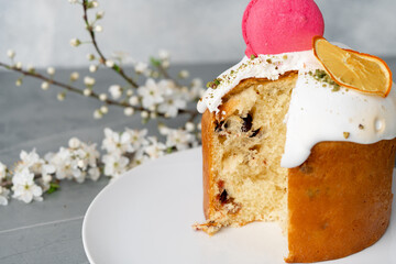 Piece of Easter cake on plate decorated with spring flower branches