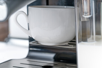 Close-up of coffee latte pouring from coffee machine. Domestic Household Appliances.