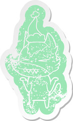 angry wolf quirky cartoon distressed sticker of a wearing santa hat