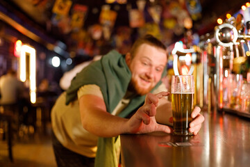 cheerful man in a pub shows him to pour beer