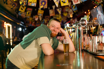 Soccer fan at the bar. happy football fan cheering at bar and drinking beer while bartender serving beer at the background