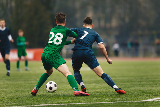 Two College Soccer Teams Playing Soccer League Game. Adult Soccer Players in a Duel. Two Football Players Competing in a Game. European Soccer Tournament Match For Adult Players.