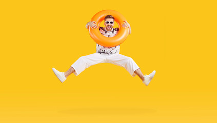 Full body photo of a happy funny man in sunglasses holding rubber ring and jumping isolated on...