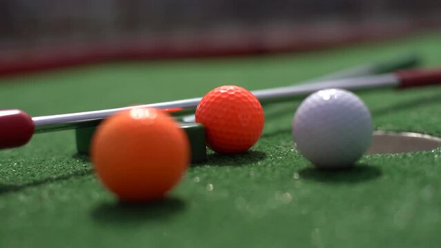 Close-up of miniature golf hole with bat and ball