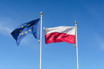 Flag of Poland and the European Union against the sky. EU and Poland concept.