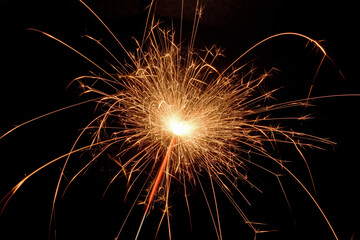 sparkler with sparks close up on black background