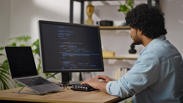 Hindus programmer works sitting at desk in cozy apartment