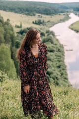 A happy young woman in a dress is dancing on a summer day outdoors.Summer,happiness, natural beauty concept.