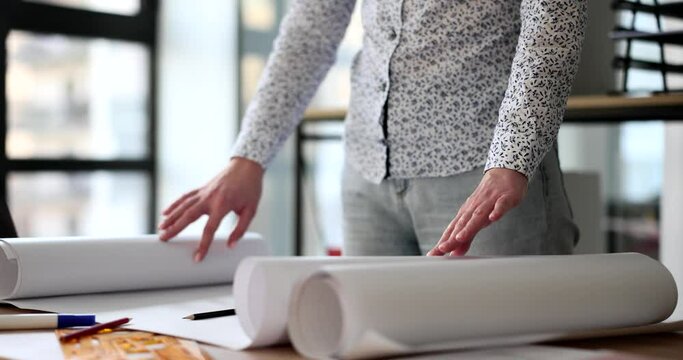 Hands of designer architect designs on whatman paper on table in office. Development drawing of construction project