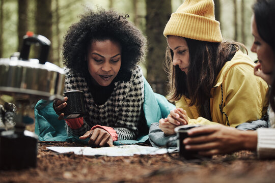 Friends reading a trail map at their camp