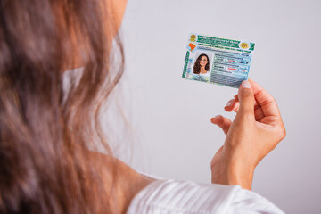 Hand holding driver's license, Brazilian document. - obrazy, fototapety, plakaty