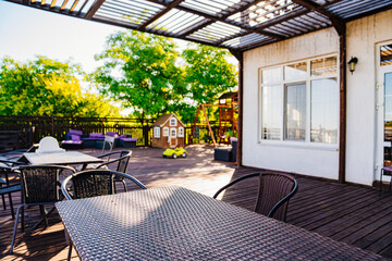 plastic wicker table on the wooden terrace for outdoor dining. a dining room.