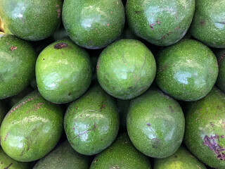 Avocados stacked un on top of each other. Fruit on display in a supermarket, filling the entire frame.