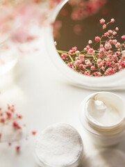 The concept of flowers and organic cosmetics. Face cream with fresh gypsophila flowers. copyspace. Morning cosmetic procedures. Spa concept, effective sustainable health formula