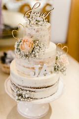 Obraz na płótnie Canvas Weiße Hochzeitstorte als Naked Cake mit Blumen verziert