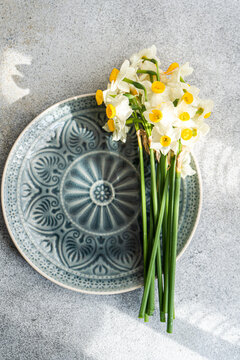 Overhead view of a ceramic plate with a bunch of daffodils