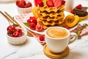 Breakfast table with stack of waffles and fresh berries