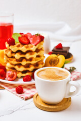 Breakfast table with stack of waffles and fresh berries