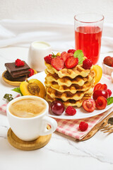 Breakfast table with stack of waffles and fresh berries