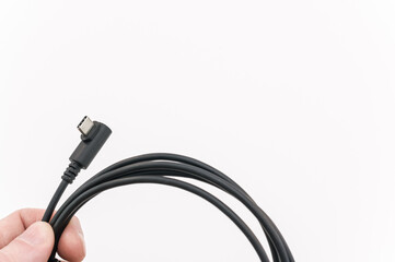 immagine con primo piano di dita che sorreggono un cavo di connessione dati USB tipo C su sfondo bianco