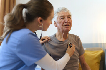 Obraz premium Young nurse checking elderly senior in his home.