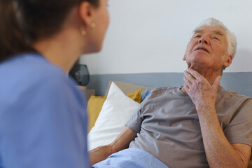 Young nurse checking elderly senior in his home.