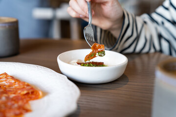 Person cutting salami in restaurant. People, food and lifestyle